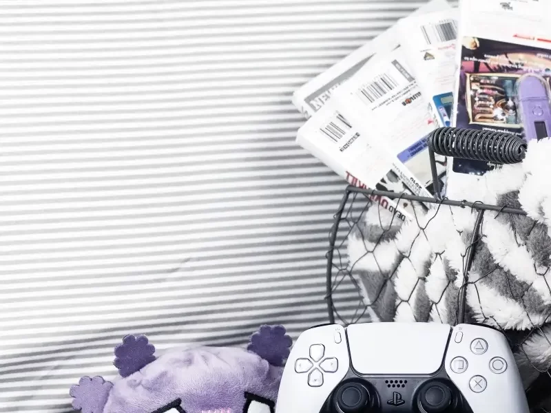 cozy games in a basket with a controller and a plushie to play when you're sick