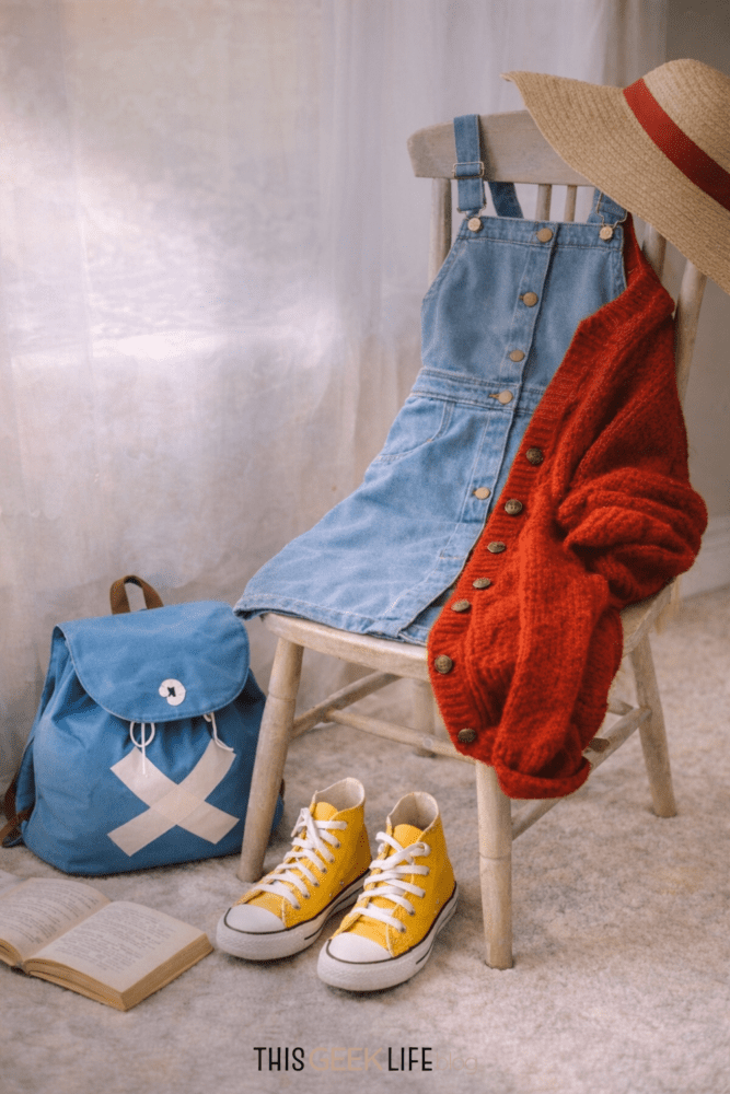 Luffy Inspired Closet Cosplay - blue denim dress, red cardigan, yellow sneakers, blue Chopper backpack, and a straw beach hat on a chair - from This Geek Life Blog