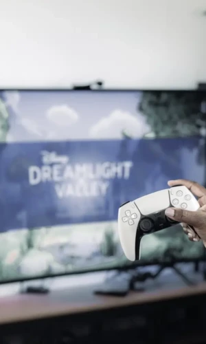 Dreamlight Valley Game Review playstation controller with hand getting ready to play Disney's Dreamlight Valley